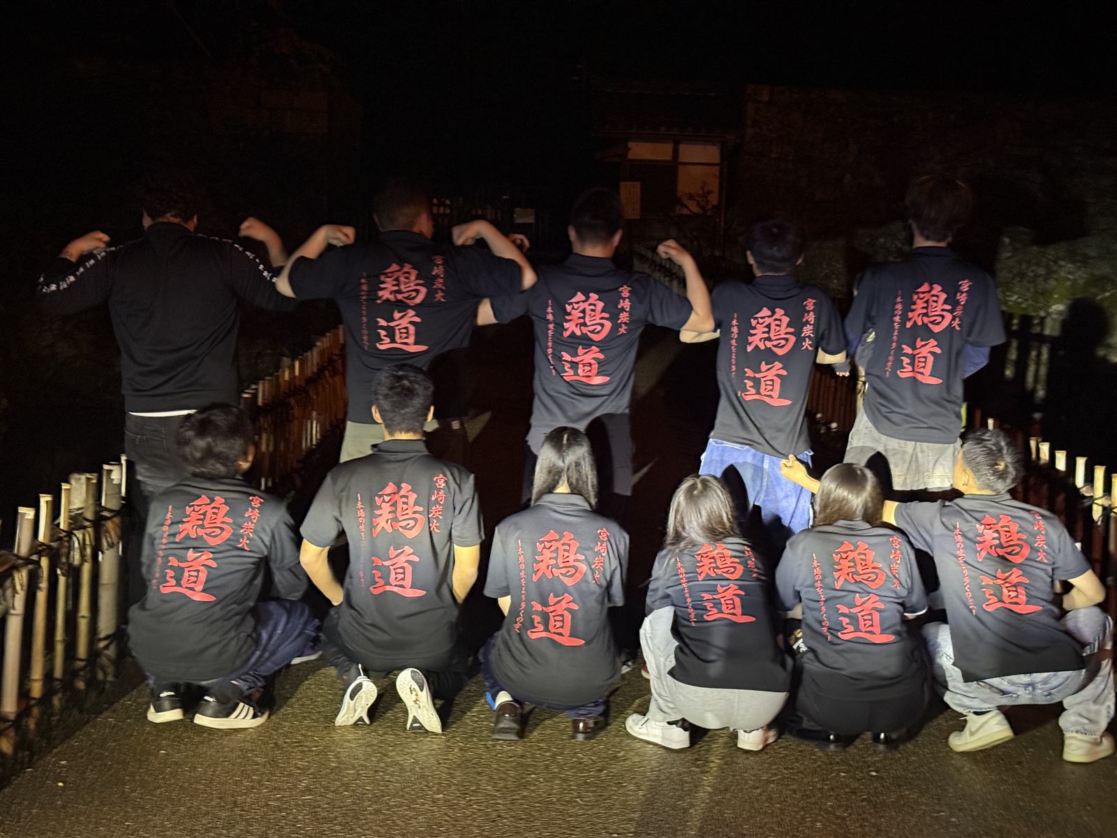 鶏道の筆文字Tシャツを着たスタッフたちの集合写真(後ろ姿)